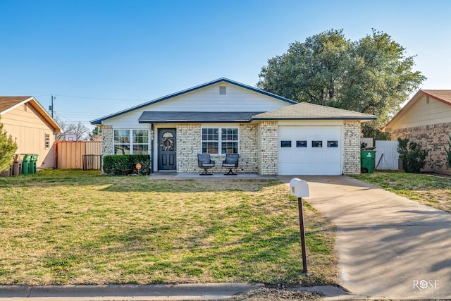 view of front of house featuring a front yard, driveway, fence, and an attached garage