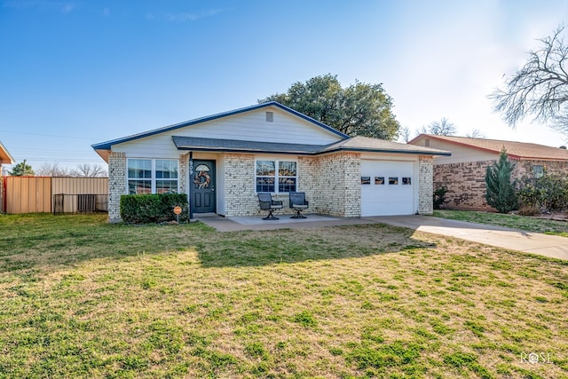 view of front of home featuring an attached garage, fence, concrete driveway, brick siding, and a front lawn