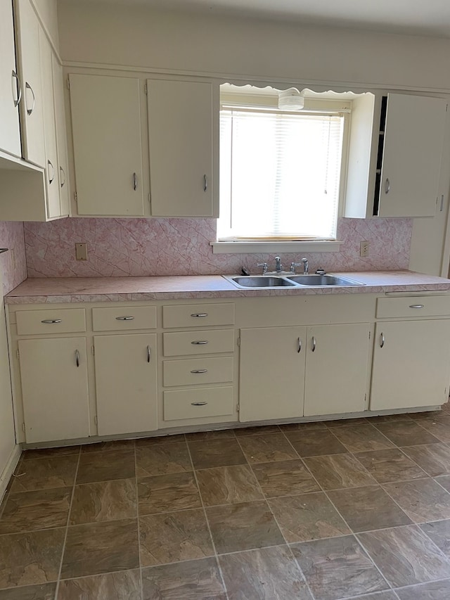 131 Oakwood St, San Angelo, TX 76903 - kitchen with a sink, light countertops, tasteful backsplash, and stone finish flooring