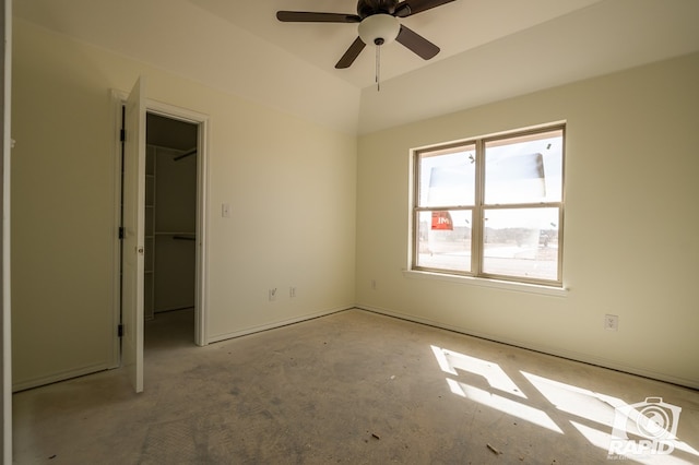 unfurnished bedroom featuring lofted ceiling, a walk in closet, and a closet