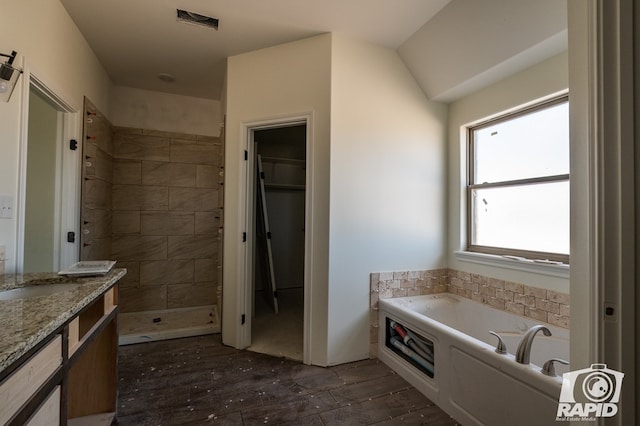 full bath featuring a walk in closet, visible vents, a shower stall, vanity, and a bath