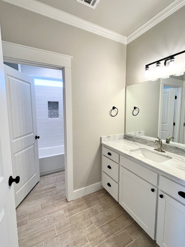 bathroom featuring ornamental molding, shower / bathing tub combination, and vanity