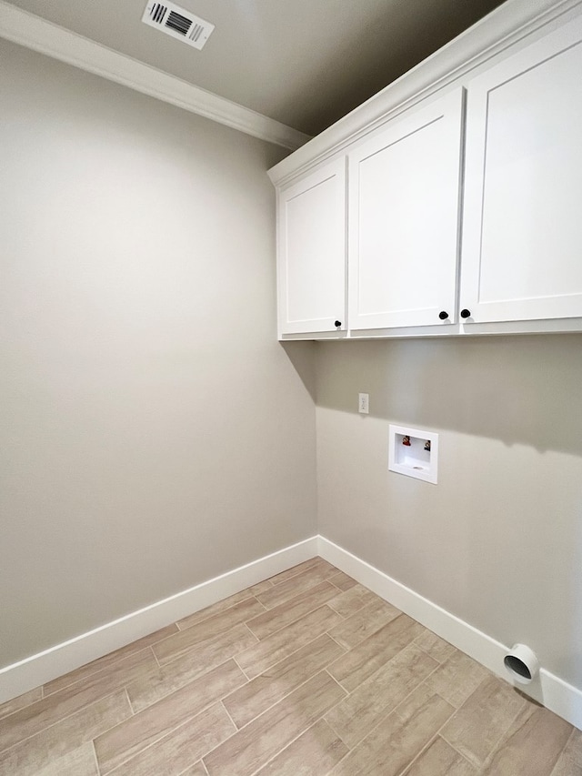 washroom with cabinets, crown molding, washer hookup, and light hardwood / wood-style floors