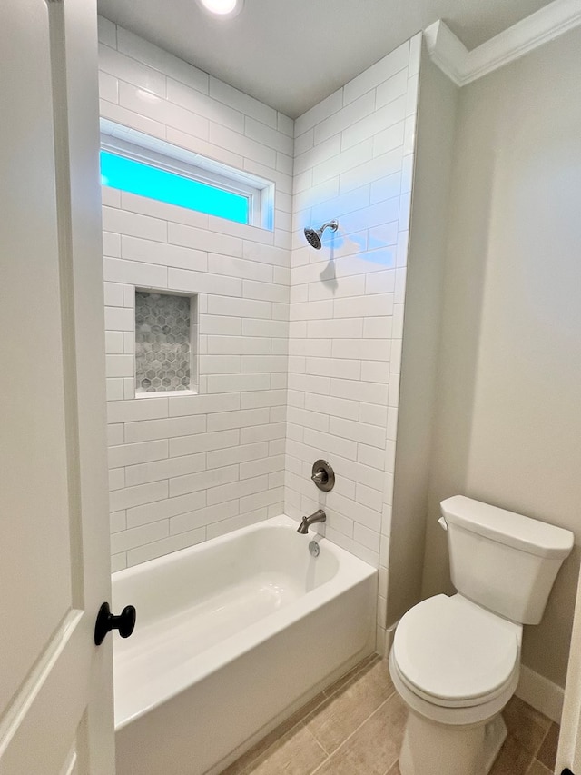 bathroom with tiled shower / bath, crown molding, and toilet