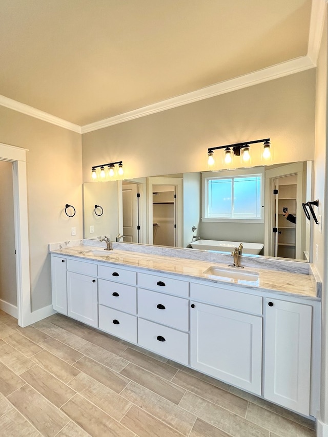 bathroom with ornamental molding, vanity, and a tub