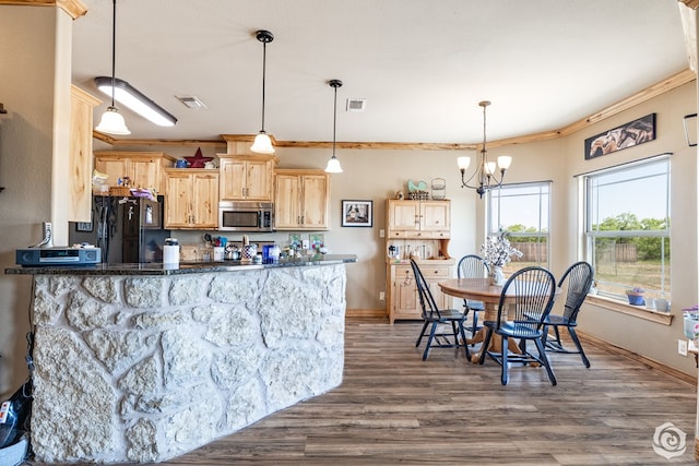 3537 Buck Run, San Angelo, TX 76901 - kitchen with stainless steel microwave, freestanding refrigerator, light brown cabinetry, and visible vents