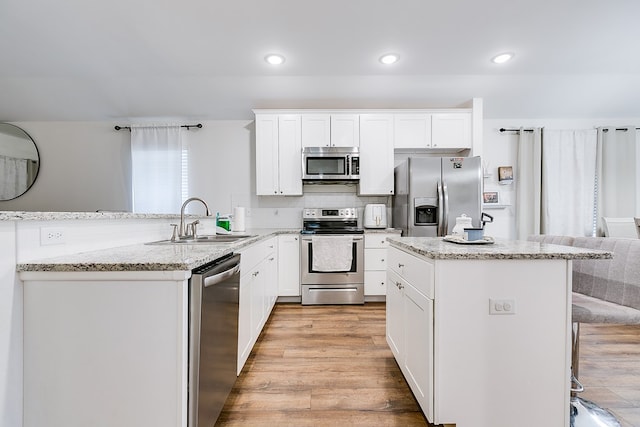 363 E 49th St, San Angelo, TX 76903 - kitchen featuring stainless steel appliances, recessed lighting, a breakfast bar, a peninsula, and light wood finished floors
