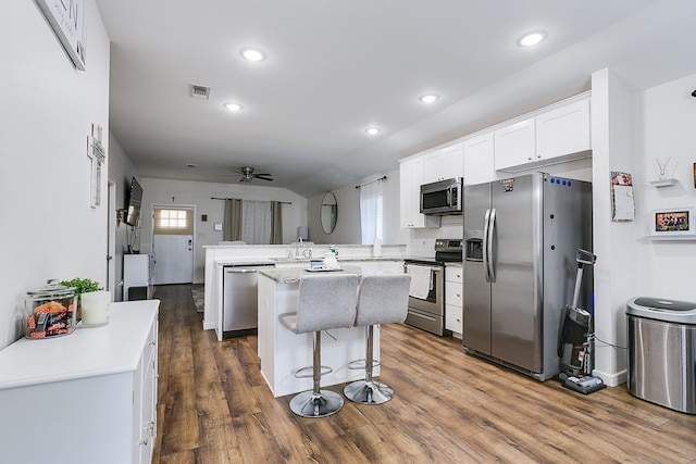 363 E 49th St, San Angelo, TX 76903 - kitchen featuring appliances with stainless steel finishes, a peninsula, dark wood-style flooring, white cabinets, and recessed lighting