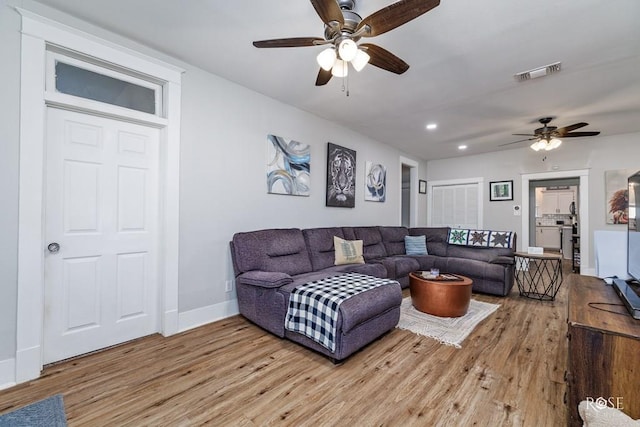 living room featuring ceiling fan and light wood-type flooring