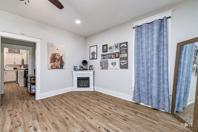 living room featuring ceiling fan and light wood-type flooring