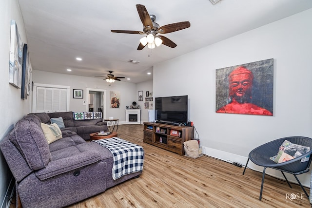 living room featuring wood-type flooring and ceiling fan