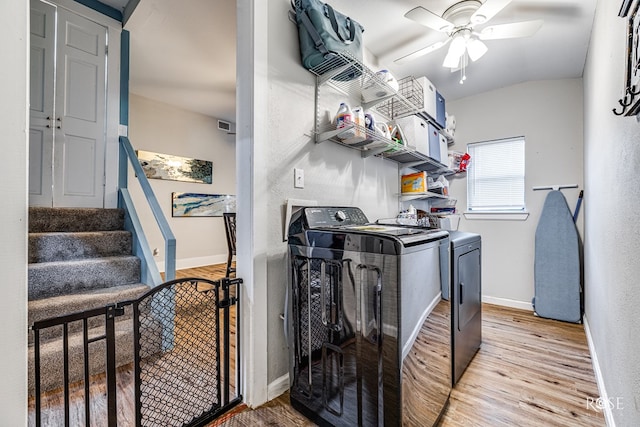 laundry area with ceiling fan, independent washer and dryer, and light hardwood / wood-style flooring