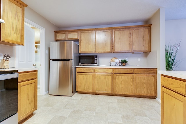 4413 Pinon Ridge Dr, San Angelo, TX 76904 - kitchen with appliances with stainless steel finishes, light countertops, and baseboards