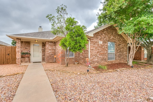 4413 Pinon Ridge Dr, San Angelo, TX 76904 - view of front of home featuring brick siding, a chimney, and a shingled roof