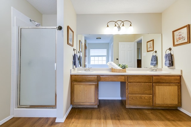 4413 Pinon Ridge Dr, San Angelo, TX 76904 - full bath with wood finished floors, double vanity, and a stall shower