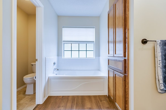 4413 Pinon Ridge Dr, San Angelo, TX 76904 - full bathroom featuring toilet, a bath, and wood finished floors