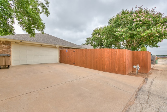 4413 Pinon Ridge Dr, San Angelo, TX 76904 - view of property exterior featuring driveway, a shingled roof, and a garage