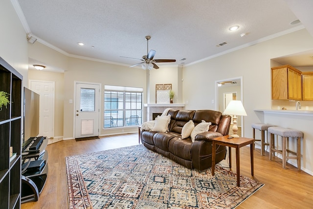 4413 Pinon Ridge Dr, San Angelo, TX 76904 - living area with crown molding, light wood-type flooring, ceiling fan, a textured ceiling, and recessed lighting