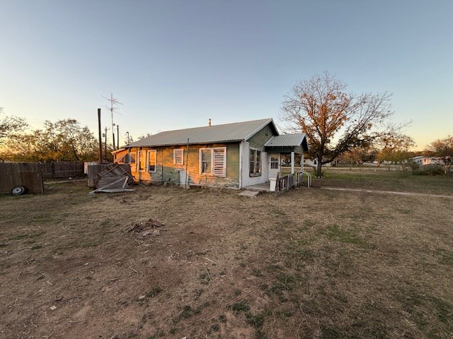 back house at dusk featuring a yard