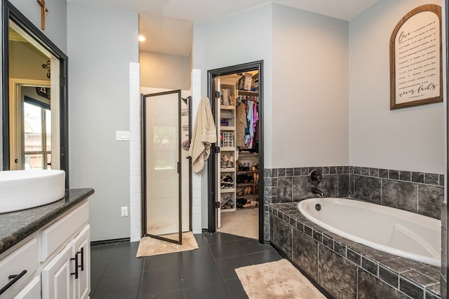 3918 Caroline Ln, San Angelo, TX 76904 - full bath featuring a shower stall, a spacious closet, a bath, vanity, and tile patterned floors