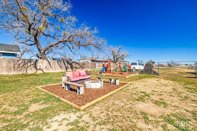 view of yard featuring a playground and an outdoor fire pit