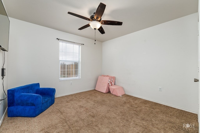 living area with light carpet and ceiling fan