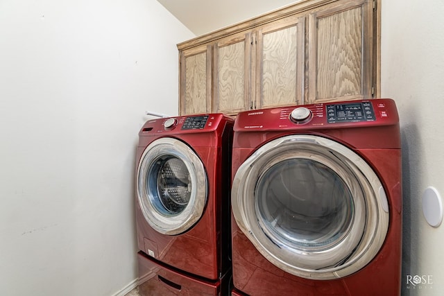 laundry area with cabinets and washing machine and clothes dryer