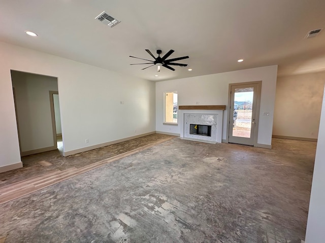 unfurnished living room featuring a premium fireplace, baseboards, visible vents, and ceiling fan