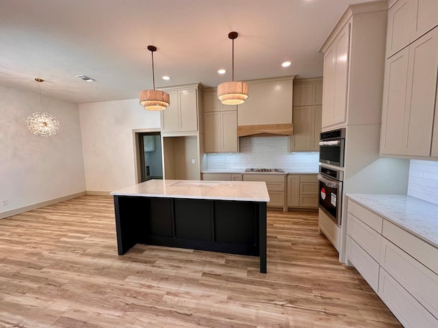 kitchen with custom range hood, light wood-style floors, tasteful backsplash, and a center island