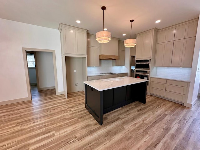 kitchen featuring custom range hood, decorative backsplash, appliances with stainless steel finishes, light wood-style floors, and hanging light fixtures