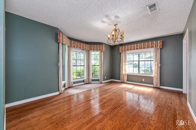 3222 Oak Mountain Trl, San Angelo, TX 76904 - spare room featuring wood finished floors, a chandelier, and a textured ceiling
