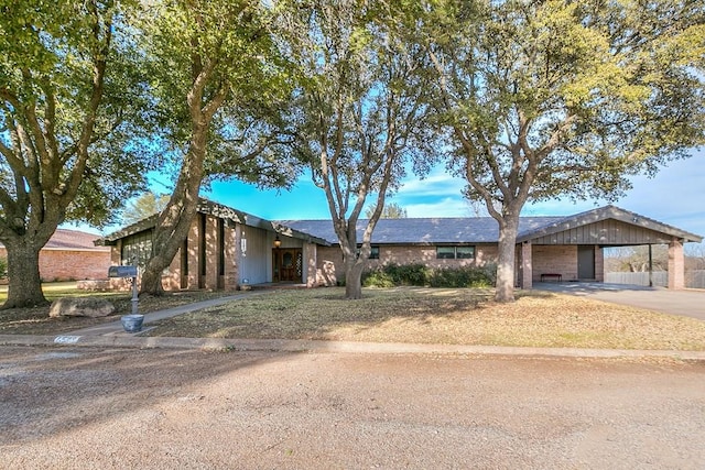 view of front of home with concrete driveway and a carport