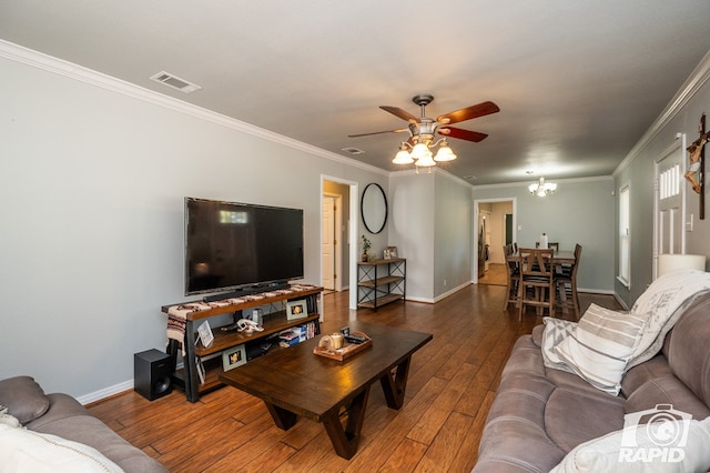 living room featuring dark hardwood / wood-style flooring, crown molding, and ceiling fan with notable chandelier