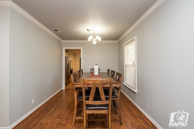 dining room featuring an inviting chandelier, crown molding, and dark wood-type flooring