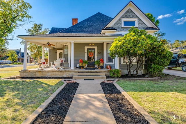 view of front of house featuring a front yard, ceiling fan, and a porch