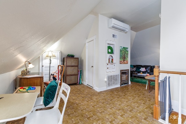 interior space with lofted ceiling, a textured ceiling, an AC wall unit, and light parquet floors