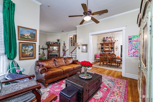 living room with ornamental molding, ceiling fan, and dark hardwood / wood-style flooring