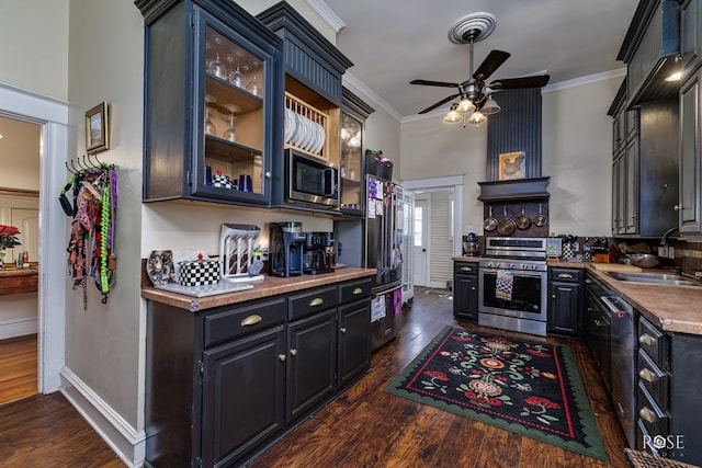 kitchen featuring dark wood-type flooring, ornamental molding, stainless steel appliances, and sink