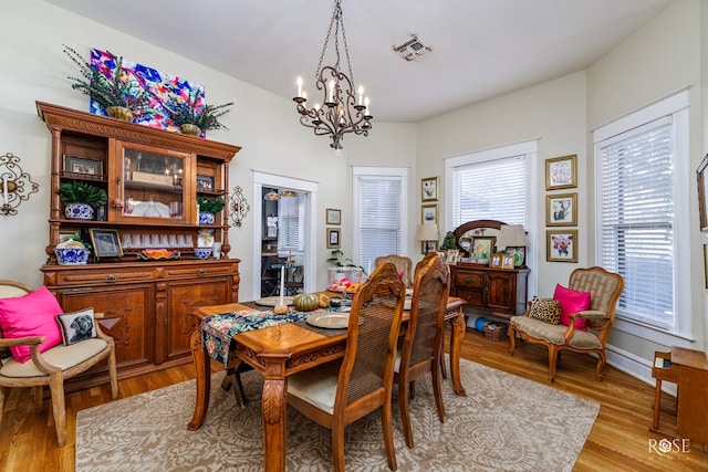 dining area featuring a notable chandelier and light hardwood / wood-style flooring