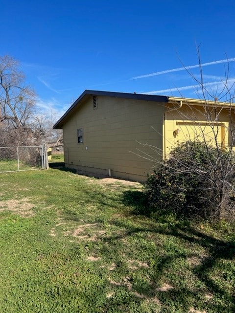 view of side of home with a yard