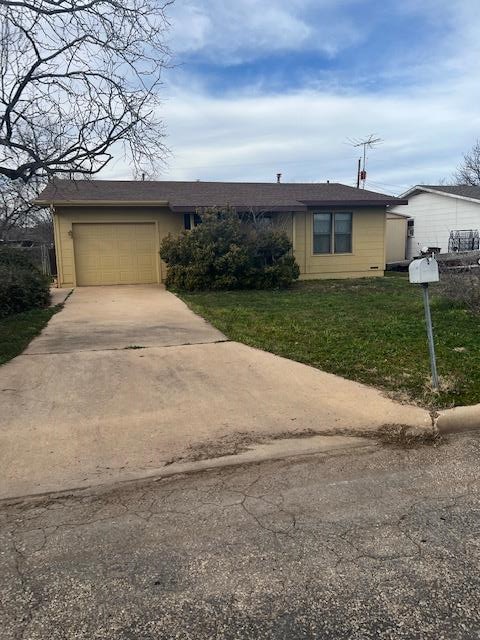 single story home with a garage and a front yard