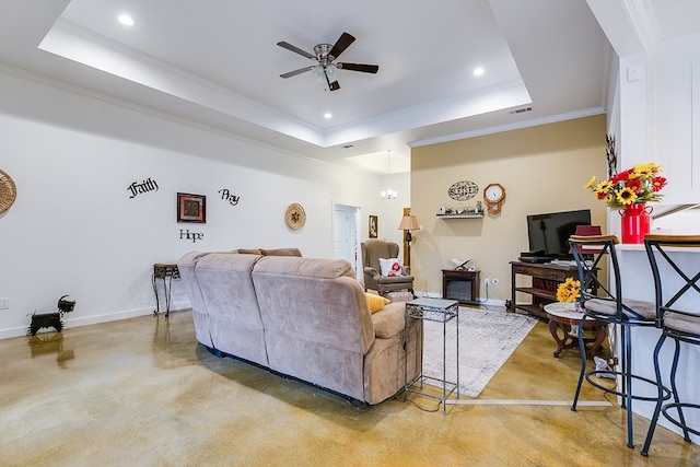 living area with baseboards, a tray ceiling, and recessed lighting