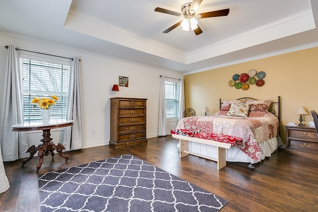 bedroom featuring ornamental molding, a tray ceiling, and wood finished floors