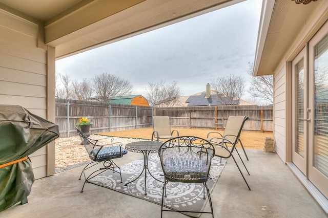 view of patio featuring outdoor dining area, a fenced backyard, and a grill