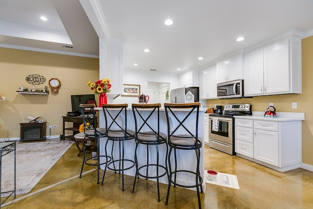 kitchen with a kitchen bar, concrete floors, appliances with stainless steel finishes, and white cabinets