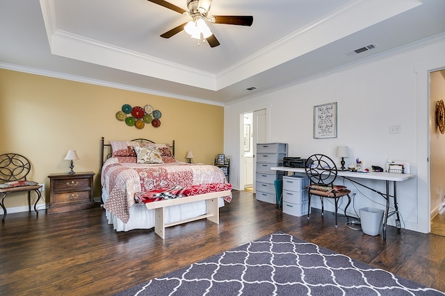 bedroom with crown molding, visible vents, a raised ceiling, and wood finished floors