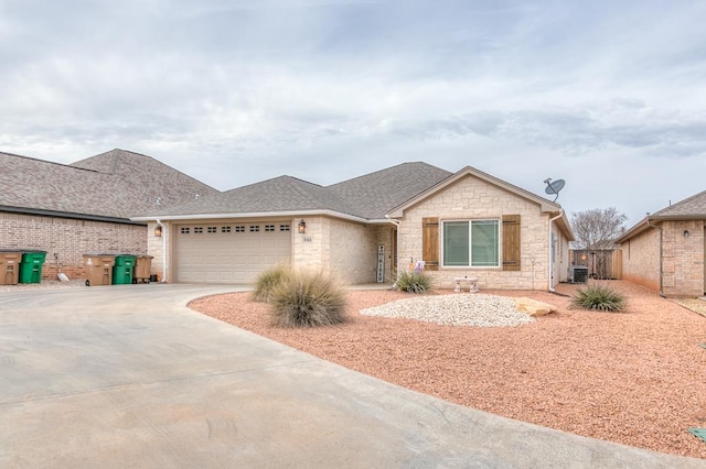 ranch-style house with an attached garage, stone siding, driveway, and a shingled roof