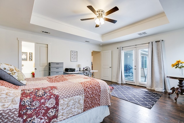 bedroom with a raised ceiling, visible vents, and access to exterior