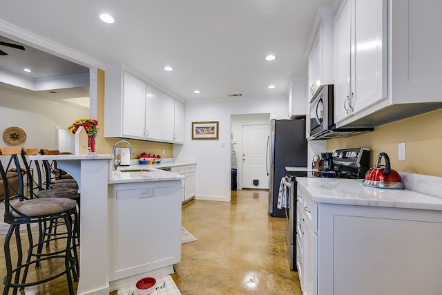 kitchen featuring white cabinets, stainless steel appliances, a sink, and recessed lighting