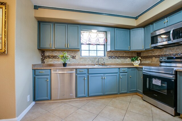 220 Mcdowell St, Bronte, TX 76933 - kitchen with appliances with stainless steel finishes, tasteful backsplash, blue cabinetry, and light tile patterned floors